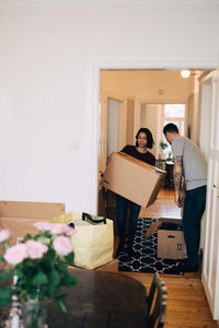 Man and woman with boxes standing in new house