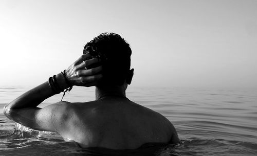 Man looking at sea against clear sky