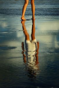 Low section of people standing on beach