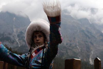 Portrait of senior woman against mountains during winter