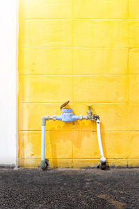 Yellow umbrella against wall