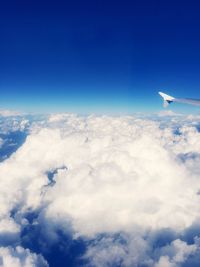 Cropped image of airplane flying over cloudscape