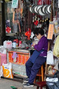 Side view of woman sitting at market