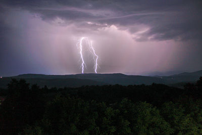 Lightning over landscape against storm clouds