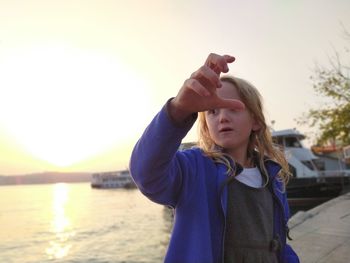 Full length of girl standing at shore against sky