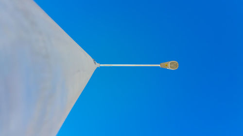 Directly below view of street light against clear blue sky