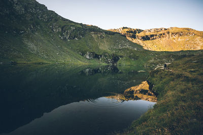 Scenic view of lake and mountains against clear sky