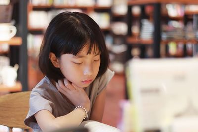 Close-up of girl reading book in library