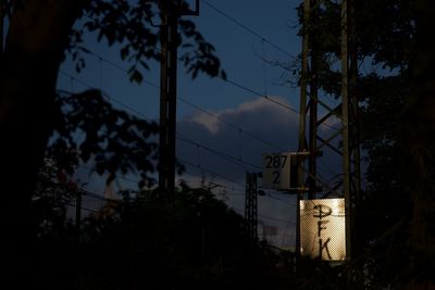 Low angle view of silhouette electricity pylon against sky