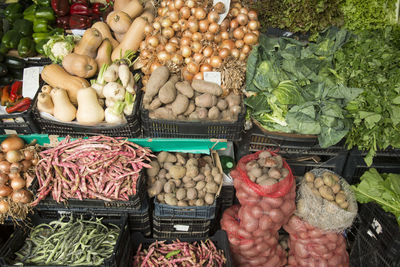 Various vegetables in crates for sale at market stall