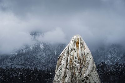 Close-up of aluminum foil against mountains during winter in foggy weather