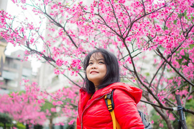 Smiling woman against pink cherry blossoms