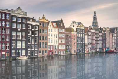 Buildings in city against cloudy sky