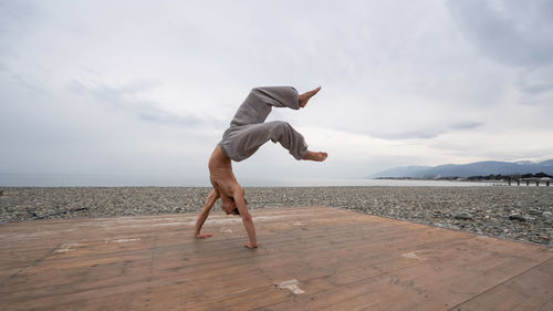 Man doing handstand at beach