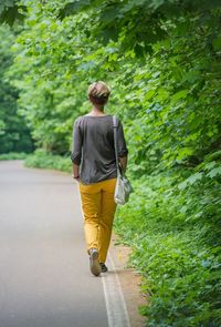 Rear view of man walking on footpath