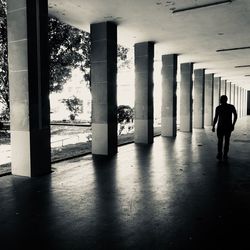 Rear view of man walking in corridor of building