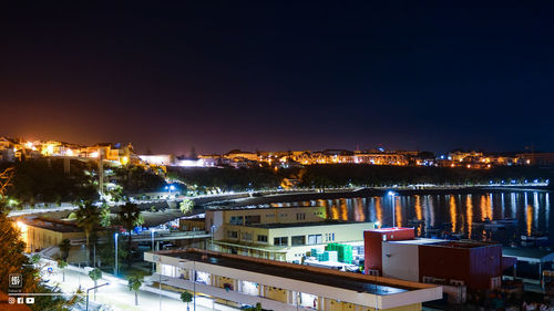 High angle view of illuminated buildings against sky at night
