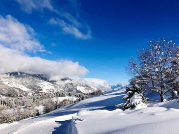 Scenic view of snowcapped mountains against blue sky