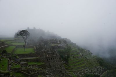 Scenic view of landscape against sky during foggy weather