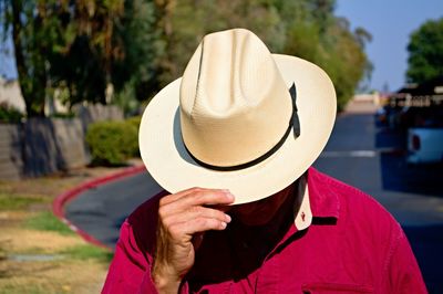 Portrait of person holding hat