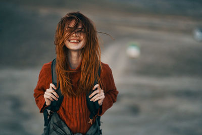 Portrait of smiling young woman standing outdoors