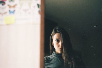 Reflection of young woman on mirror