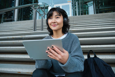 Portrait of young woman using digital tablet