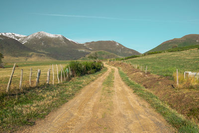 Road amidst field against sky