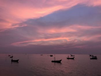 Silhouette boats in sea against sky during sunset