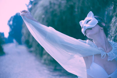 Close-up of woman wearing mask and cape