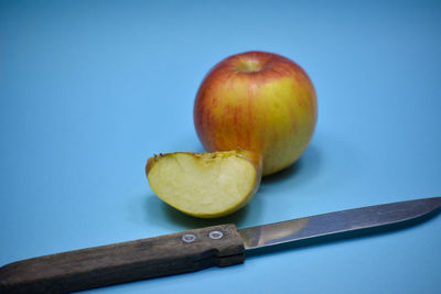 Close-up of apple on table against blue background