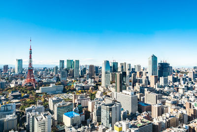 Aerial view of city buildings against blue sky