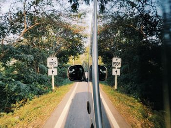 Road amidst trees seen through car windshield