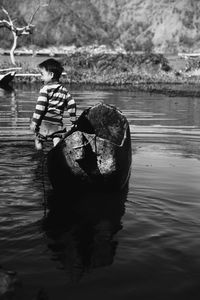 Rear view of boy standing in lake