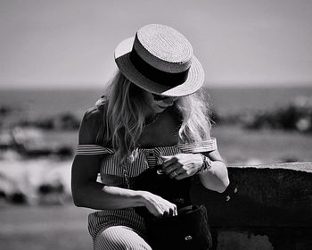 Midsection of woman wearing hat at beach