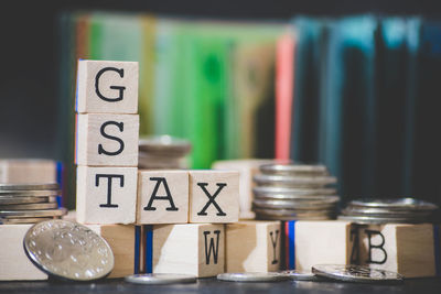 Close-up of toy blocks with text and coins on table