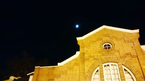 Low angle view of illuminated building against sky at night