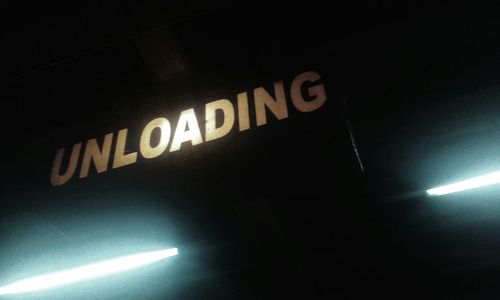 Low angle view of illuminated information sign at night