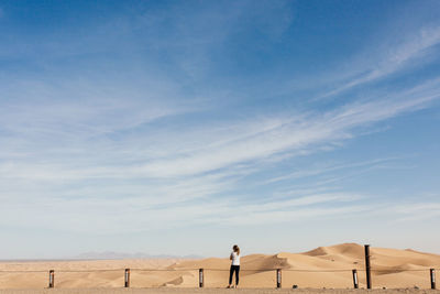 Rear view of a woman standing at desert