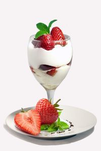 Close-up of strawberries in plate against white background