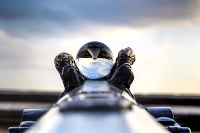 Close-up of camera on car against sky