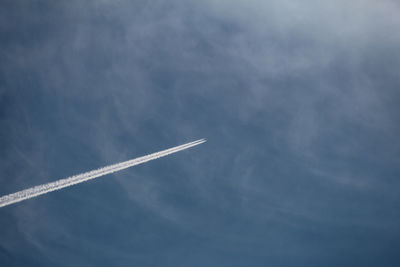 Low angle view of airplane flying against sky