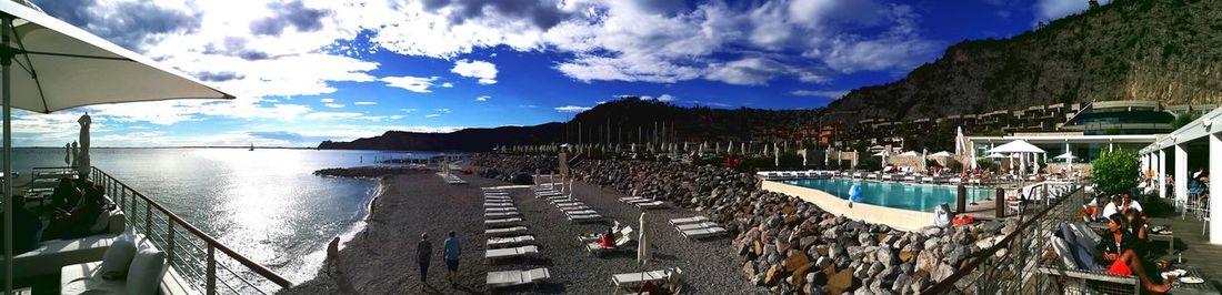 Panoramic view of boats moored at harbor against sky