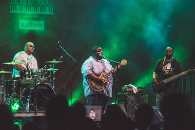 People playing guitar at music concert