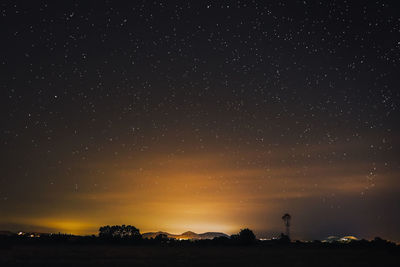 Scenic view of silhouette field against sky at night