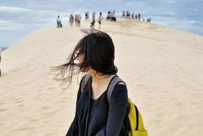 Rear view of woman standing at beach