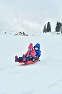 People in snow against sky during winter