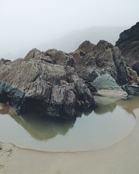 Scenic view of rock formation in sea against sky