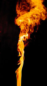 Close-up of fire burning against black background