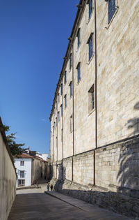 Street amidst buildings against clear blue sky